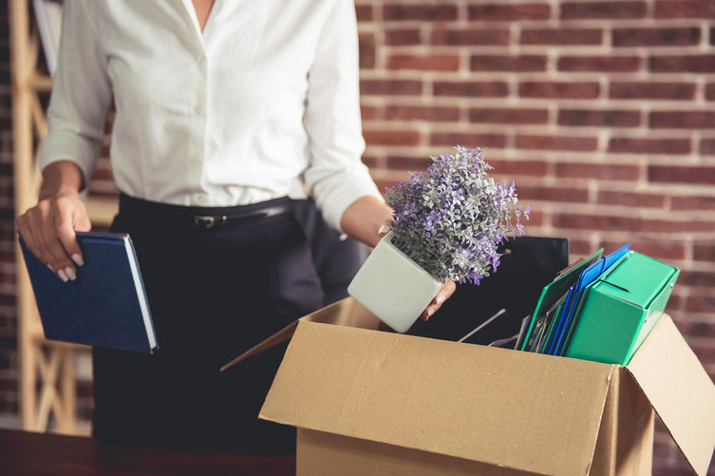 kobieta zwolniona z pracy pakuje swoje rzeczy