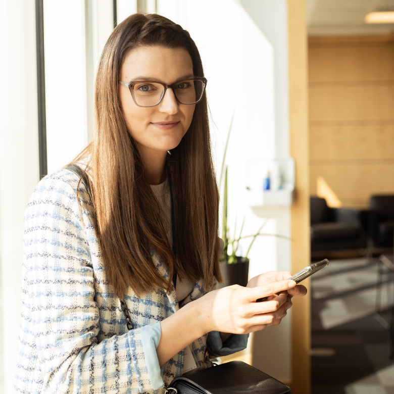 Dziewczyna siedzi w oknie z telefonem