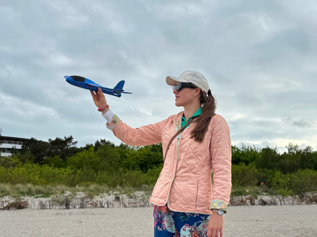 Marzena Meryk-Skubis na plaży z samolotem w dłoni